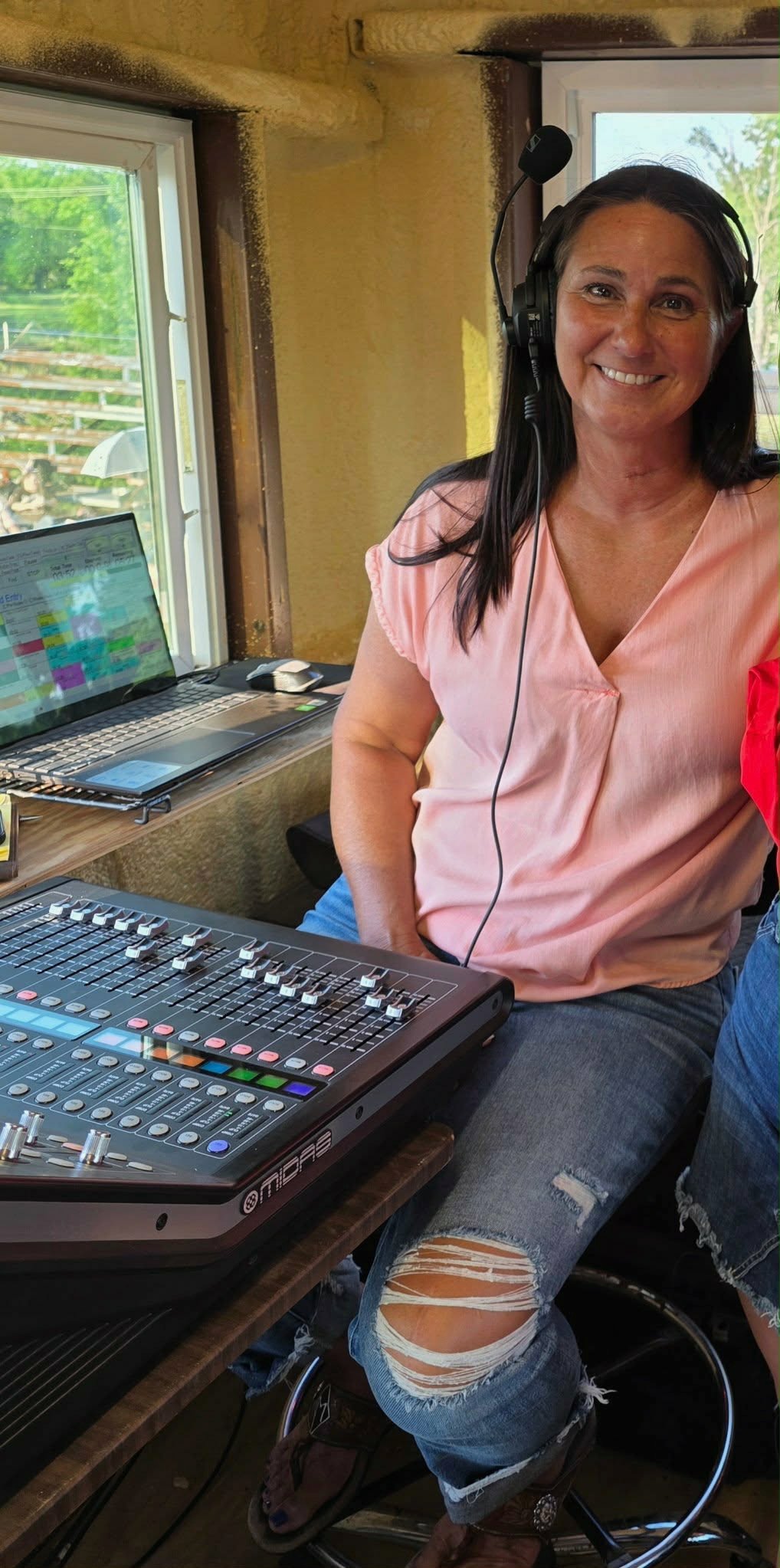 Michelle McLelland wearing a headset at her rodeo audio mixing console.